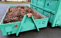 tin container for storing biowaste from a gardening company branches of leaves and cut grass open iron painted Royalty Free Stock Photo