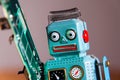 Tin toy robot carries computer circuit board, artificial intelligence concept Royalty Free Stock Photo