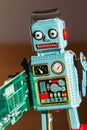 Tin toy robot carries computer circuit board, artificial intelligence concept Royalty Free Stock Photo