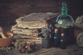 Tincture bottles, assortment of dried healthy herbs, old books, wooden mortar, sack of medicinal herbs. Herbal medicine.