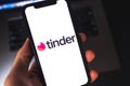 Tinder logo on smartphone screen.