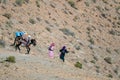 Tinghir, Atlas Mountains, Morocco - November 27, 2022 - Moroccan mountain village women walking for water with donkey and mule