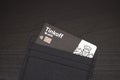 Tinkoff black debit card in a business card holder on a wooden background