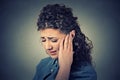 Tinnitus. Closeup sick female having ear pain touching painful head Royalty Free Stock Photo