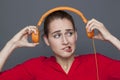 Tinnitus headphones concept for dubious 20s girl Royalty Free Stock Photo
