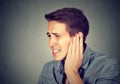 Tinnitus. Sick man having ear pain touching his painful head Royalty Free Stock Photo