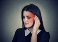 Tinnitus. Sick woman having ear pain colored in red head Royalty Free Stock Photo