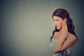 Tinnitus. Side profile sick young woman having ear pain touching her painful head Royalty Free Stock Photo