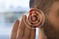 Tinnitus. Young man with hearing problems or hearing loss. Hearing test concept. Royalty Free Stock Photo