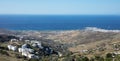 Tinos island, Cyclades Greece. Rocky land and white houses, blue sea and sky