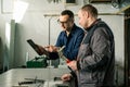 A tinsmith and his fellow colleague engineer in the workshop Royalty Free Stock Photo