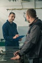 A tinsmith is sketching in his workshop with a colleague engineer who is taking notes Royalty Free Stock Photo
