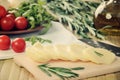 tinted image sliced cheese, tomatoes and herbs on a kitchen table closeup