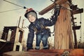 Tinted image smiling boy sits on suspension bridge and looking a