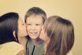 Tinted image two teens girls kissing little laughing boy Royalty Free Stock Photo