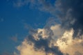 TINTED WHITE CLOUD WITH SMOKY WISPY CLOUD AGAINST A BLUE SKY