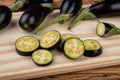 Tiny baby eggplants with slices over wooden board Royalty Free Stock Photo