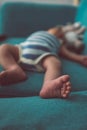 Tiny baby foot close up lying on a green sofa Royalty Free Stock Photo