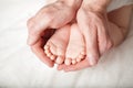 Tiny baby`s feet in male hand Royalty Free Stock Photo