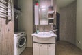 Tiny bathroom with toilet, sink, mirror, laundry cabinet Royalty Free Stock Photo