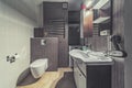 Tiny bathroom with toilet, sink, mirror, laundry cabinet Royalty Free Stock Photo