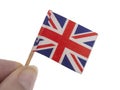 Tiny, battered and damaged Union Jack, United Kingdom flag in fingers, isolated on white background.