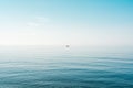 Seascape and the horizon with tiny sailing boat