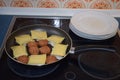 tiny burgers, Maultaschen and white back bacon, plates next to the pan