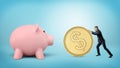 A tiny businessman rolls a huge golden dollar coin in the direction of a giant piggy bank. Royalty Free Stock Photo