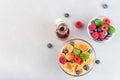 Tiny cereal pancakes served with maple syrup, raspberry and blueberry, in glass bowl, horizontal, top view, copy space Royalty Free Stock Photo