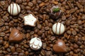 Tiny chocolate in heart shape on coffee beans. Close up.