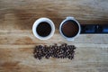 Tiny coffee pink ceramic cup with espresso, raw beans, coffee holder on wooden table or background from above.