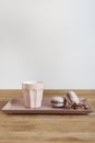 Tiny coffee pink ceramic cup and macarons on wooden table or background, white wall behind Royalty Free Stock Photo