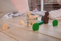 Tiny colorful wooden toy shapes and building blocks on hardwood floor.Girl play with a wooden set in their children`s Royalty Free Stock Photo