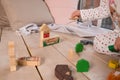 Tiny colorful wooden toy shapes and building blocks on hardwood floor.Girl play with a wooden set in their children`s Royalty Free Stock Photo