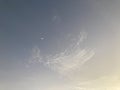 Tiny crescent moon with an amazing shape of light white clouds Royalty Free Stock Photo