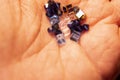 Tiny crystals being held in woman`s hand, miniature crystal chips. Macro photo in natural lighting.Blurred photo