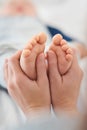 So tiny and delicate. Closeup shot of a mother holding her little baby boys feet. Royalty Free Stock Photo