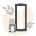 A tiny elderly man sits on a chair next to a giant hourglass. Ageing problems.