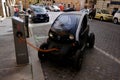 Tiny Electric Car charging on the street in Rome