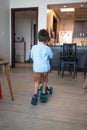 Tiny explorer: Cute toddler\'s blue push scooter adventures at home