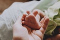 Tiny feet of newborn baby in mother`s hand. Maternity, infancy concept. Royalty Free Stock Photo