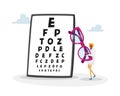 Tiny Female Doctor Carry Huge Eyeglasses front of Chart for Vision Checkup. Eyes Diseases Treatment and Diagnostics Royalty Free Stock Photo