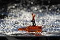 A tiny figure of a person standing on a miniature empty beer bottle. Alcoholism and moderate consumption problem Royalty Free Stock Photo