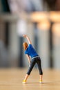 Tiny figurine of a woman in athletic wear performing a side stretch Royalty Free Stock Photo