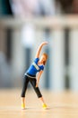 Tiny figurine of a woman in athletic wear performing a side stretch Royalty Free Stock Photo