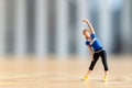 Tiny figurine of a woman in athletic wear performing a side stretch Royalty Free Stock Photo