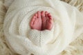 The tiny foot of a newborn baby. Soft feet of a new born in a wool white blanket Royalty Free Stock Photo