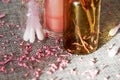 Tiny glass jar with cotton buds, pink lip gloss and scented flower petals Royalty Free Stock Photo