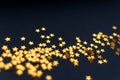 Tiny golden stars on a black background, top view, carnival, night party invitation or festive background, starry night sky